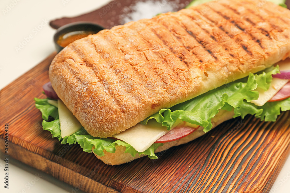 浅色背景上有美味的ciabatta三明治的木板