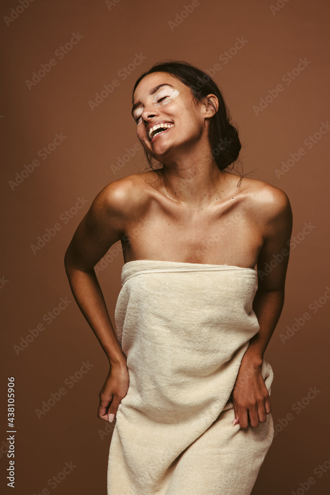 快乐的女人在浴巾里跳舞