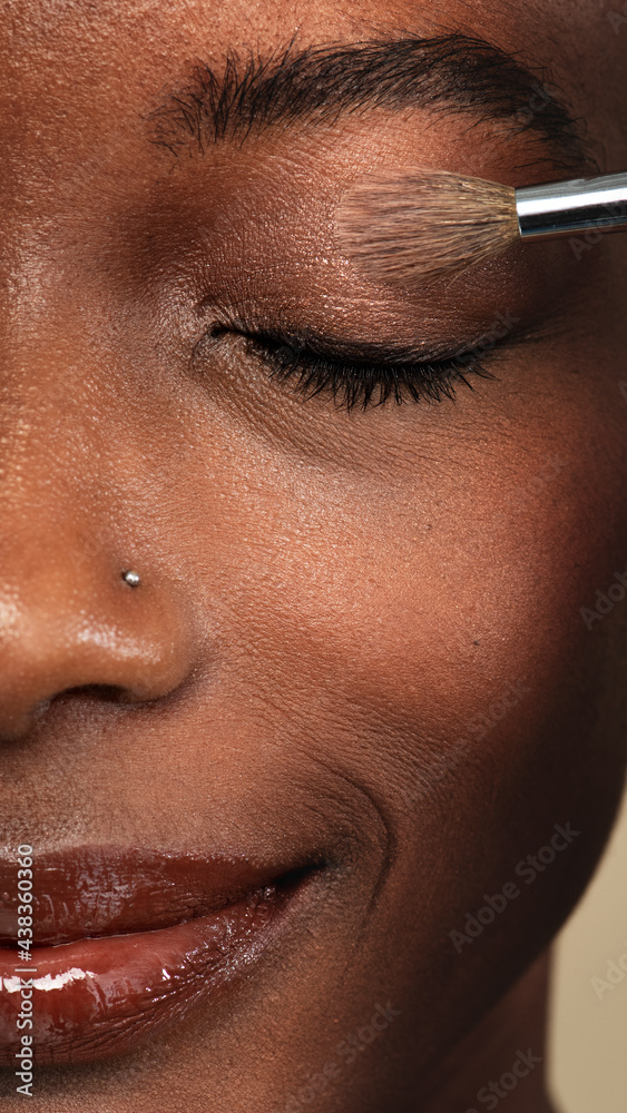 化妆师在黑人女性身上涂抹眼影