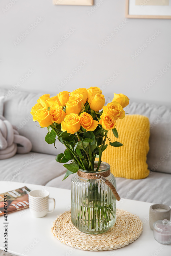 客厅桌子上放着黄玫瑰的花瓶