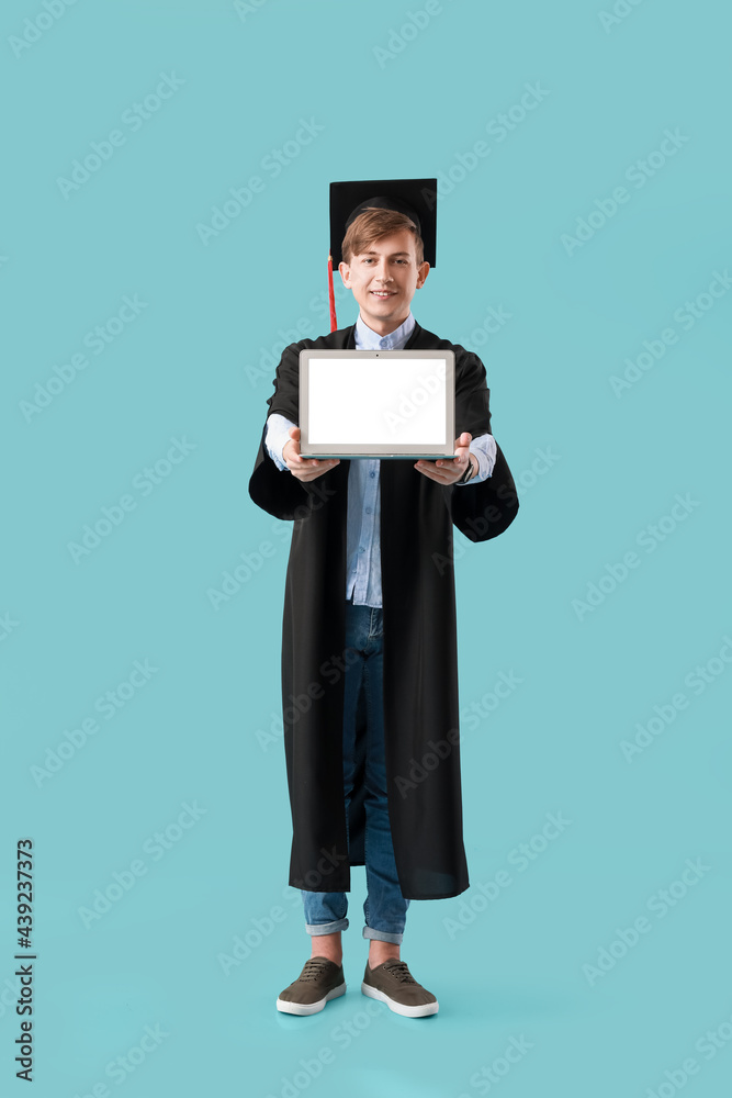 男毕业生，彩色背景笔记本电脑