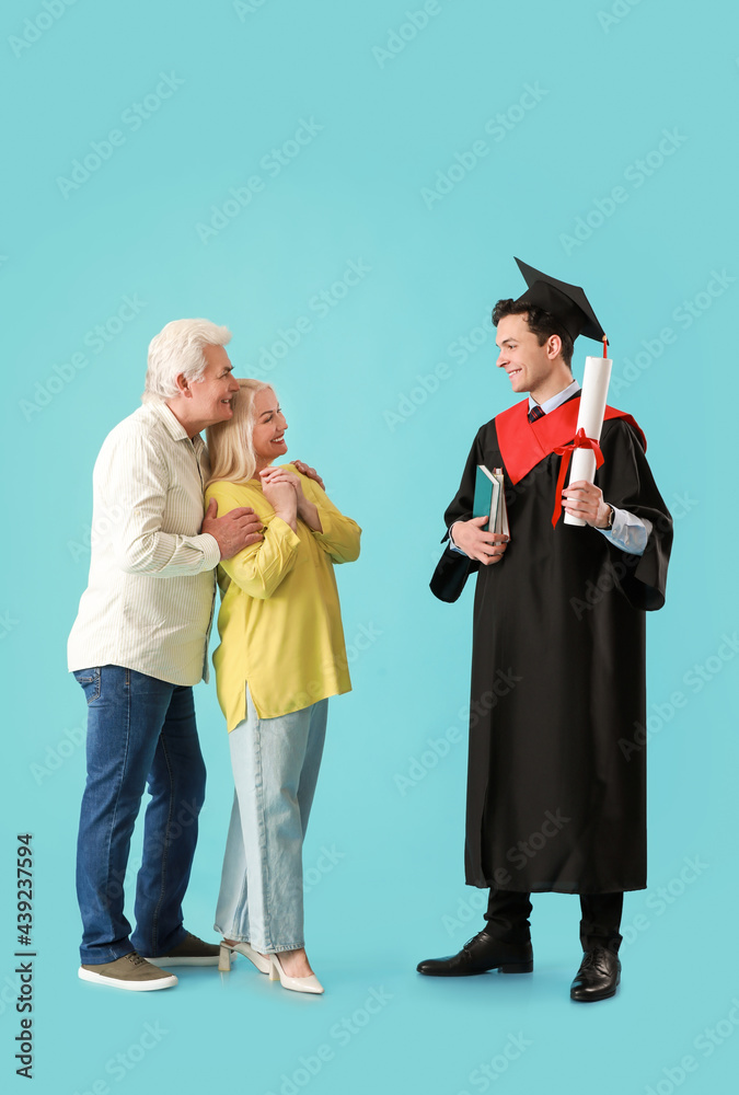 快乐的男毕业学生和他的父母在彩色背景上