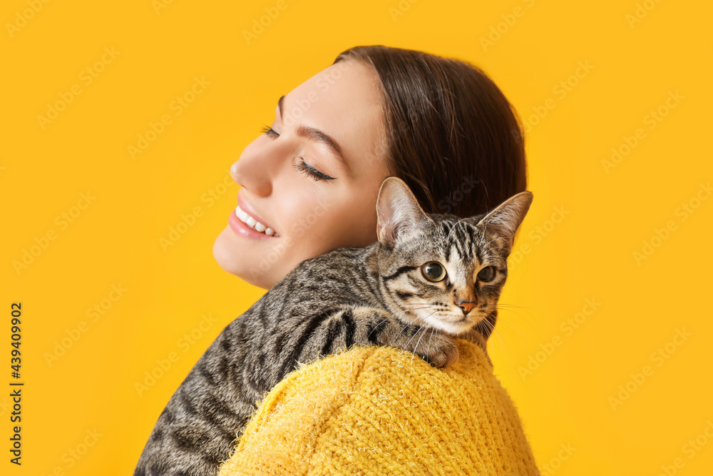 年轻女子，彩色背景上有一只可爱的猫