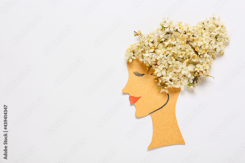 Paper female figure with beautiful fruit tree flowers on light background