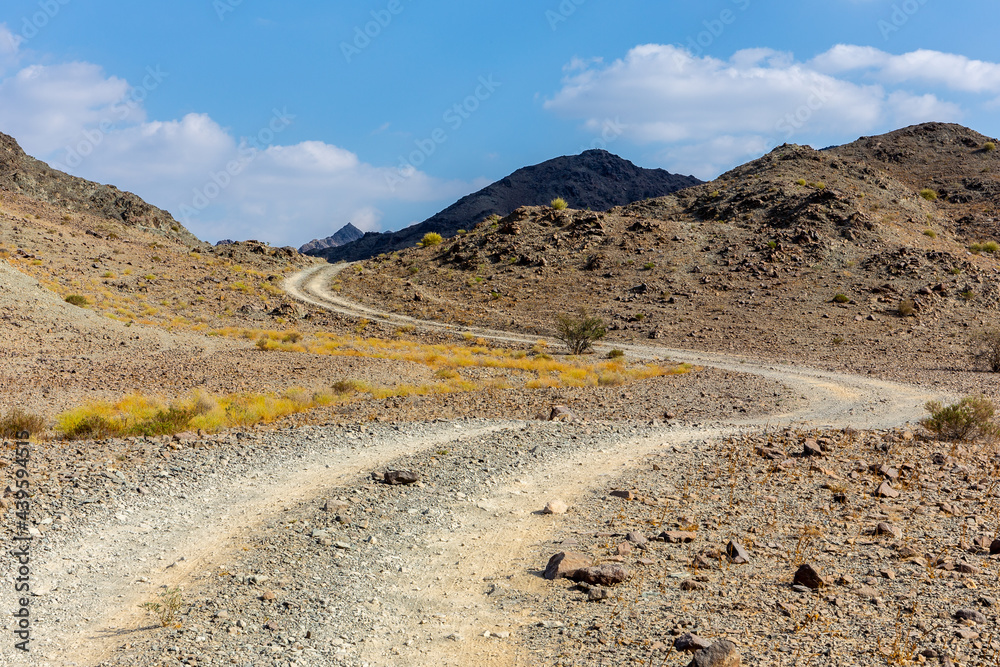 铜徒步小径，蜿蜒的砾石土路，穿过Wadi Ghargur河床和岩石石灰岩Hajar