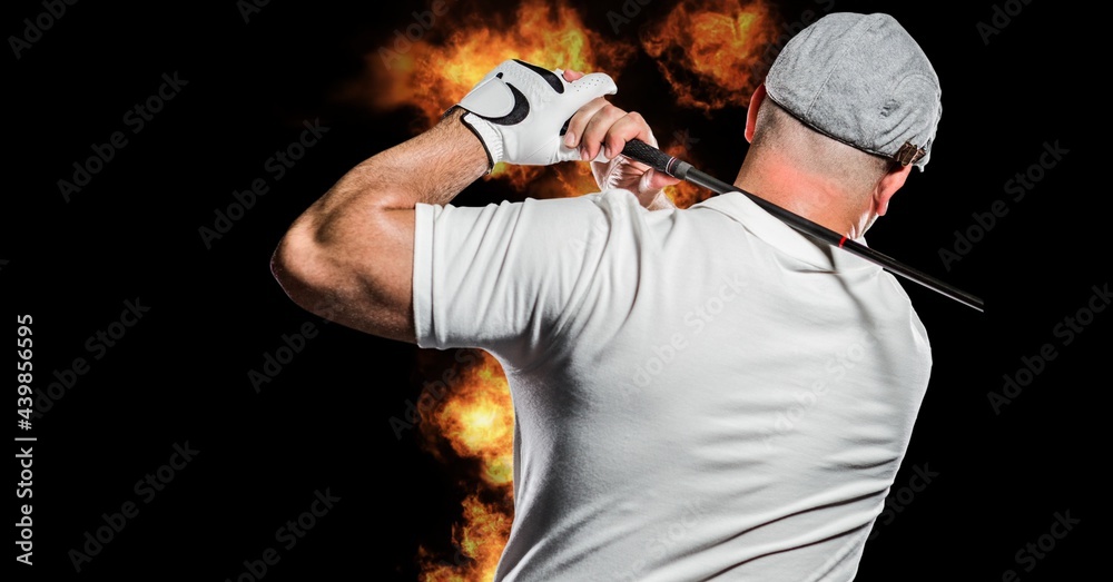 高加索男子高尔夫球手在黑色背景下挥舞球杆对抗火焰效果的后视图