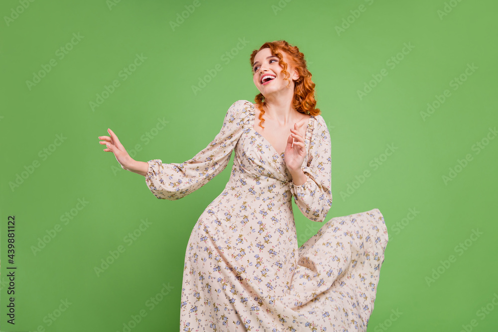 Photo of cheerful positive pretty young woman look empty space fly dress isolated on green color bac