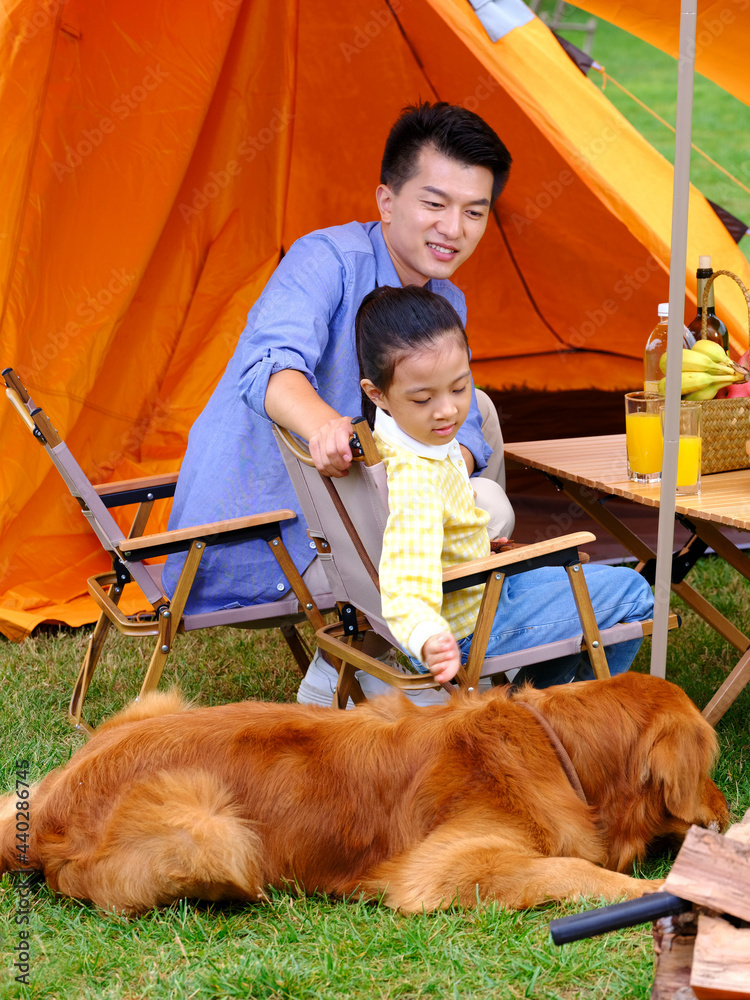 快乐的父女带着他们的宠物狗露营