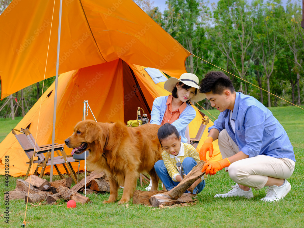 Happy family of three and dog camping out