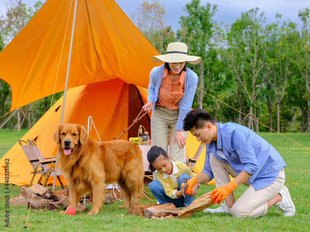 Happy family of three and dog camping out