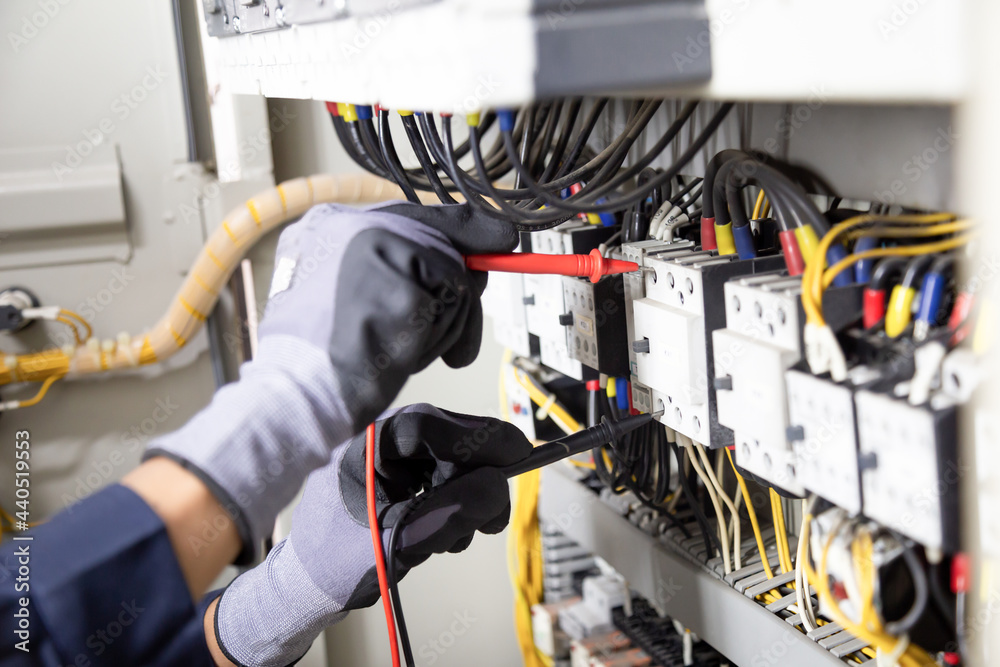 电工工程师测试继电保护系统上的电气装置和电线。调整