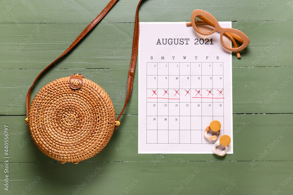 彩色木制背景上带有标记日期和女性配件的日历