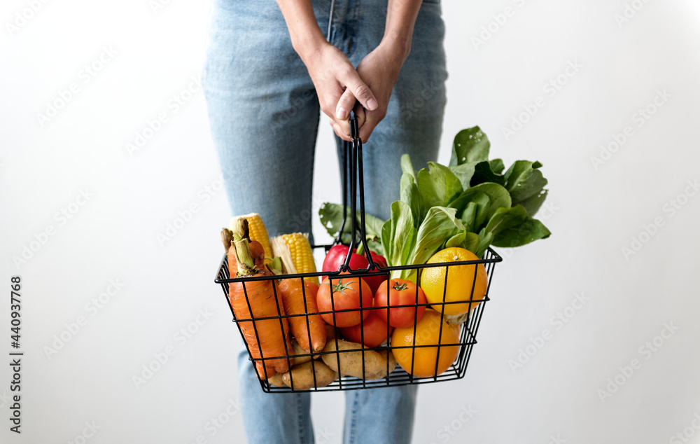 拿着一篮子蔬菜的女人