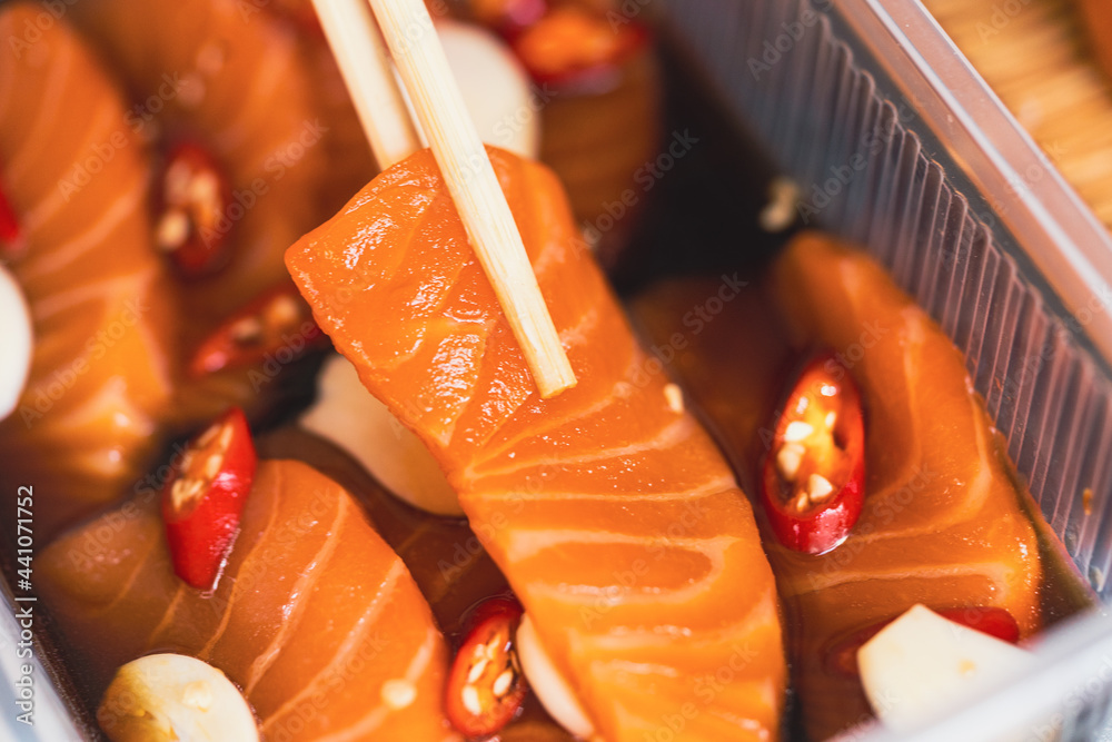 新鲜生三文鱼片，在外卖盒上用温和的酱油盐水腌制。亚洲人吃
