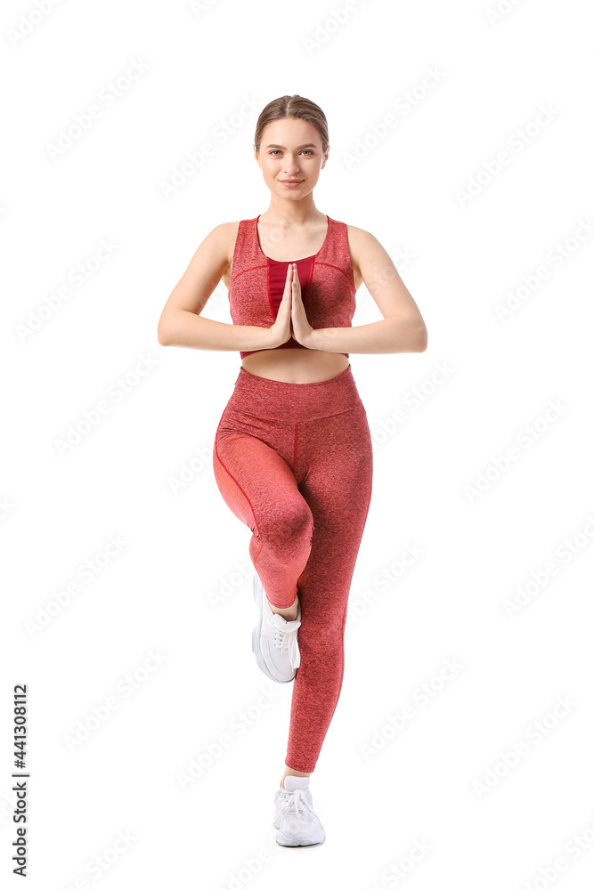 在白色背景下做瑜伽的运动型年轻女性