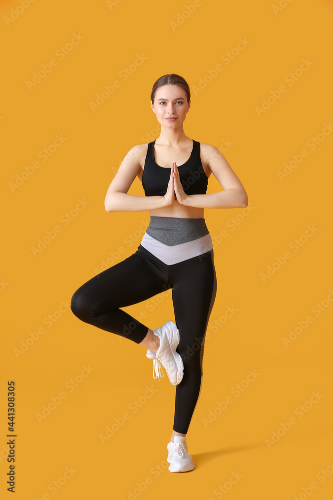 运动型年轻女子在彩色背景下做瑜伽