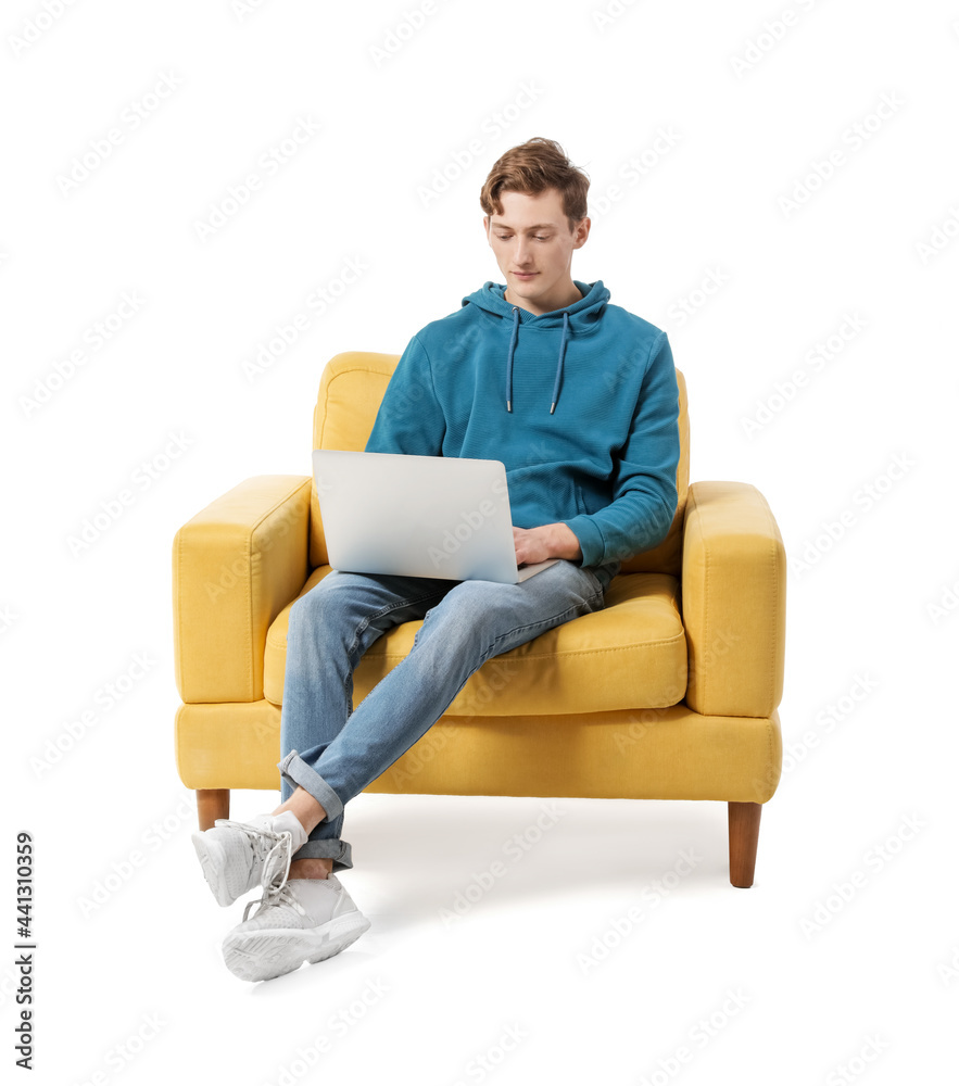 年轻人拿着笔记本电脑坐在白底扶手椅上