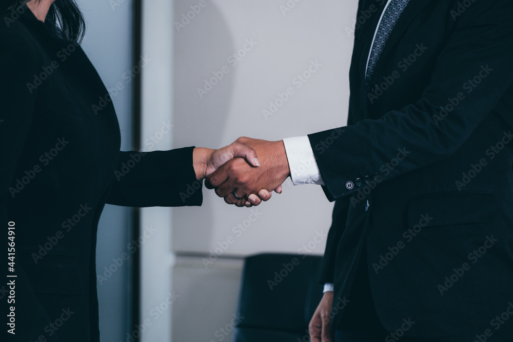 商务人士协议概念。商人和亚洲女商人在办公室握手。