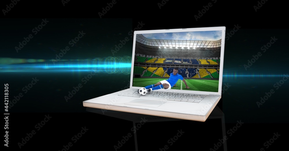 笔记本电脑中的男足球运动员在体育场踢球的构成