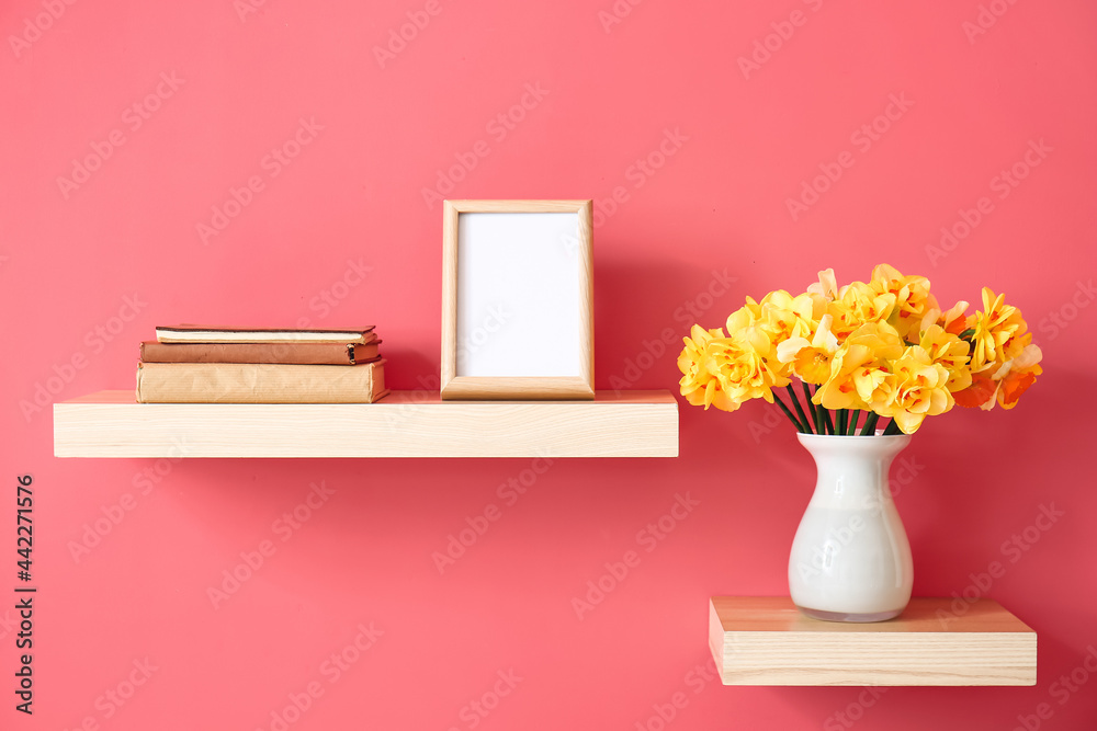 花瓶上挂着美丽的水仙花，书架上挂着彩色墙上的书