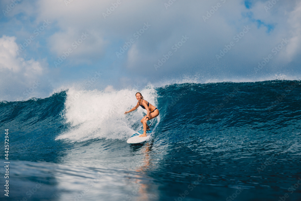 冲浪女子在完美的海浪上冲浪板。海洋冲浪中的年轻运动女性。
