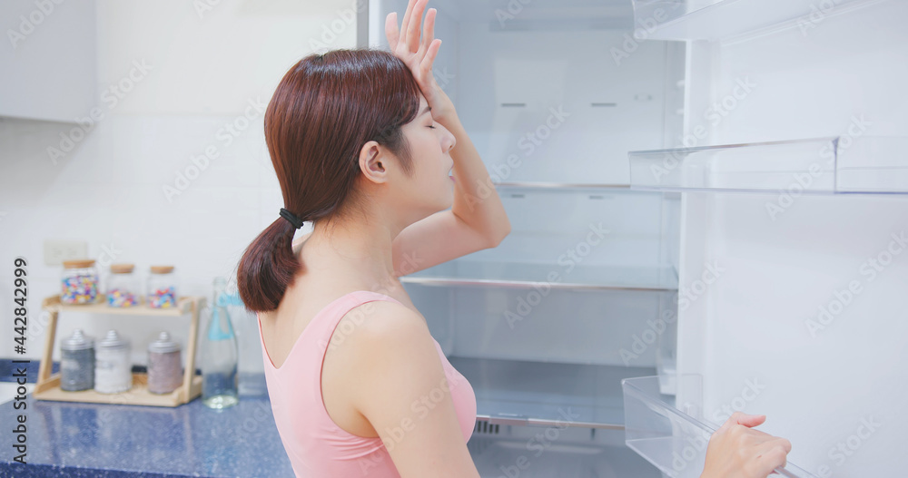 女人看着空冰箱