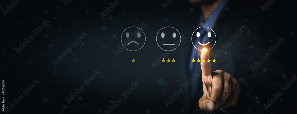 客户服务和满意度概念商人在虚拟屏幕上触摸快乐的笑脸图标