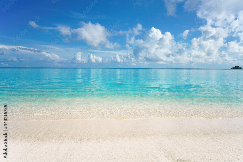 Beautiful sandy beach with white sand and rolling calm wave of turquoise ocean on Sunny day. White c