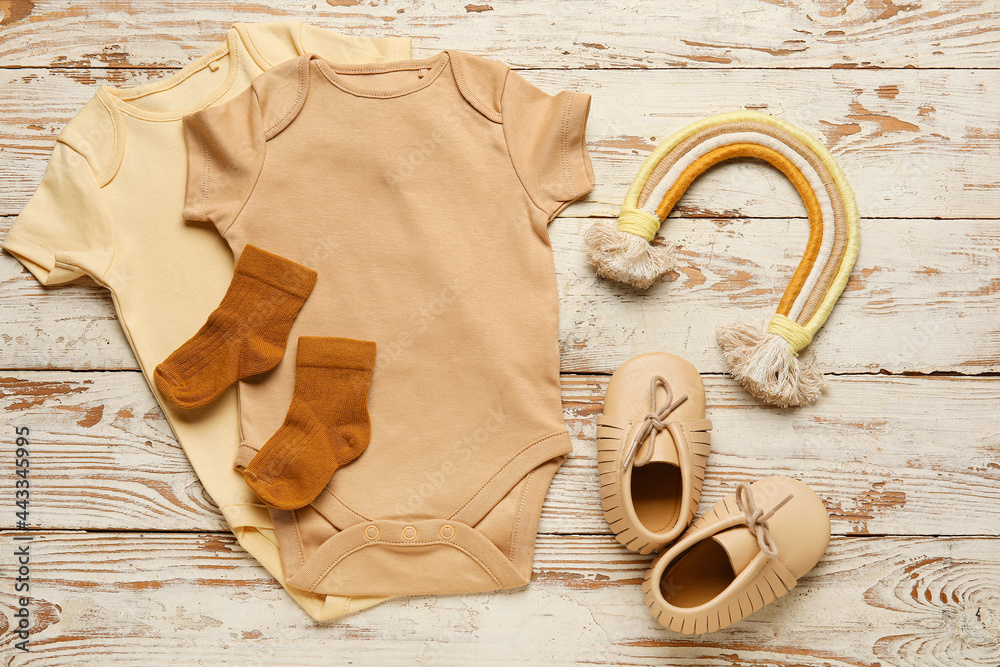 浅色木质背景的婴儿衣服和鞋子