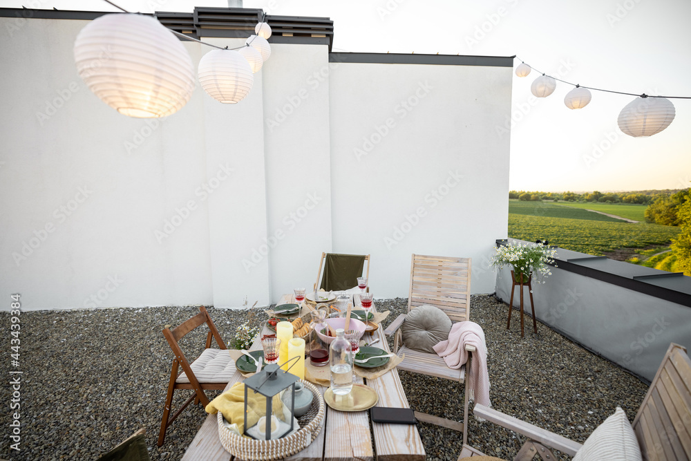 装饰精美的屋顶露台，自然波西米亚风格，夏天餐桌上摆满了食物