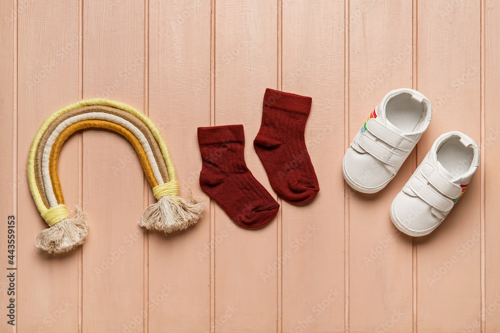 婴儿袜子、鞋子和玩具彩色木制背景