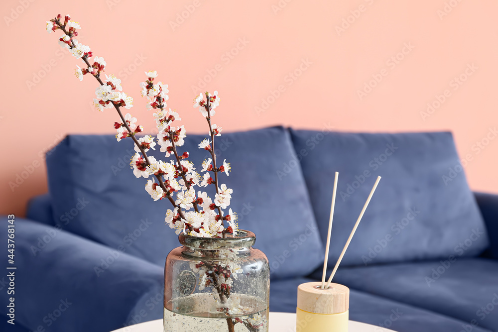 房间桌子上放着春天盛开的树枝的花瓶