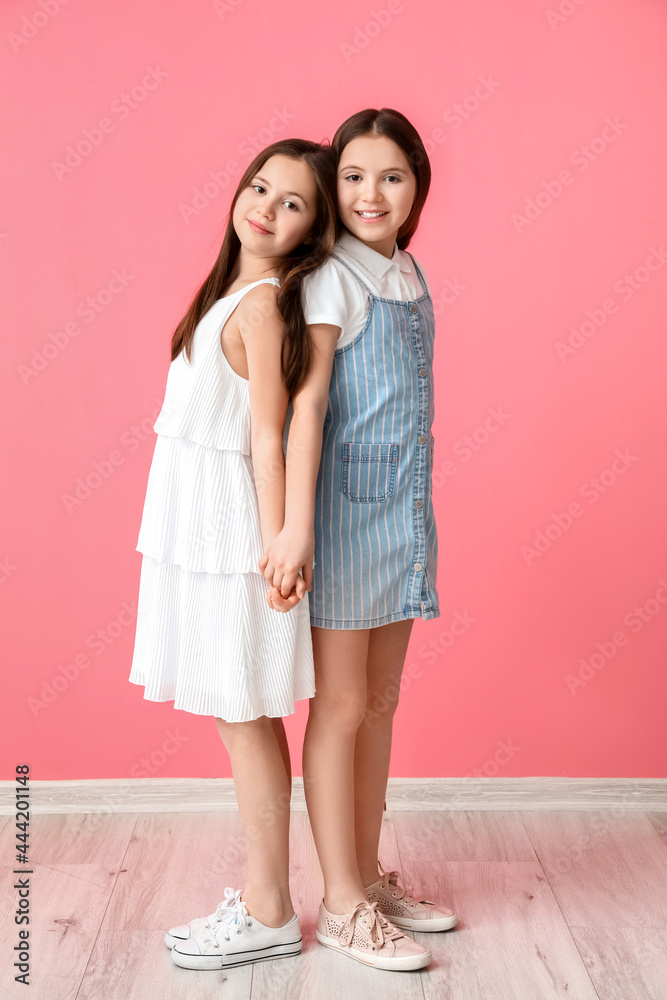 彩色背景的可爱双胞胎女孩