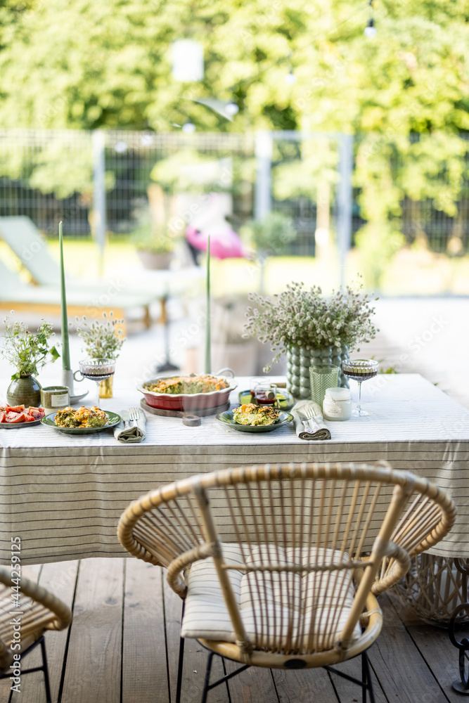 花园里的桌子上铺着桌布，用鲜花和蜡烛装饰着食物