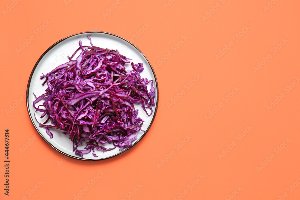 彩色背景上有切好的新鲜紫色卷心菜的盘子