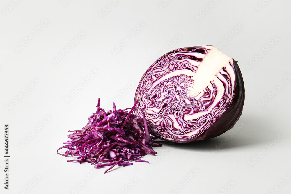 在浅色背景下切新鲜的紫色卷心菜