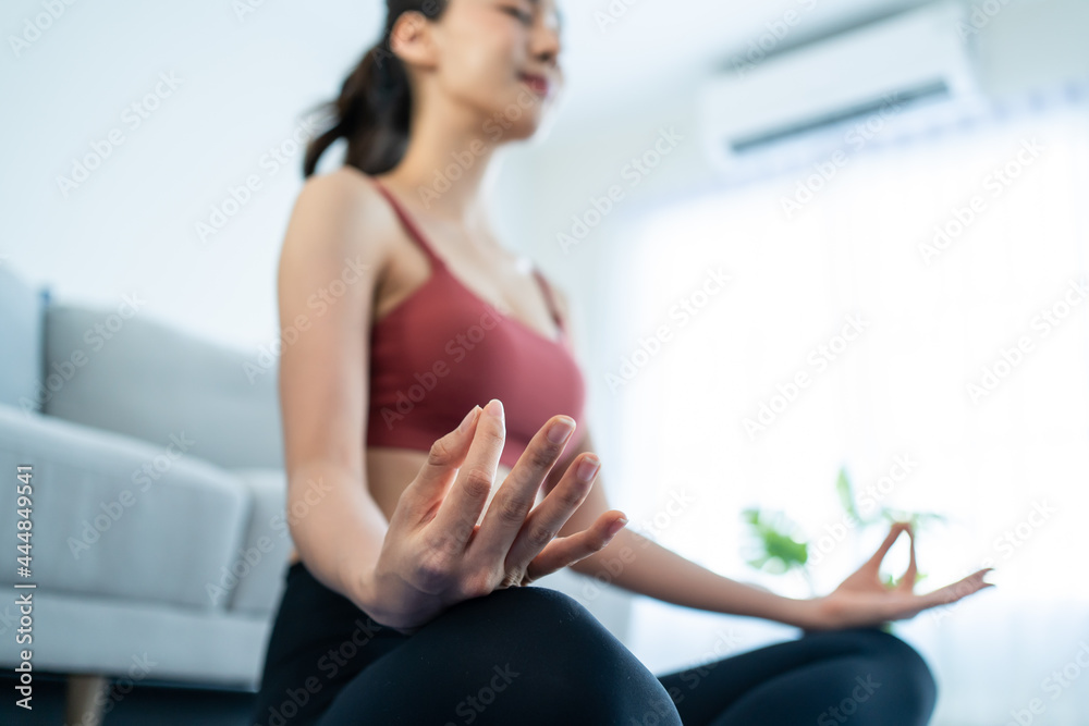 亚洲年轻漂亮的活跃女性在家做瑜伽普拉提锻炼。