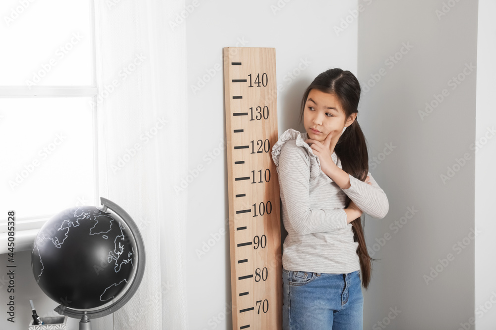 小女孩在家测量身高