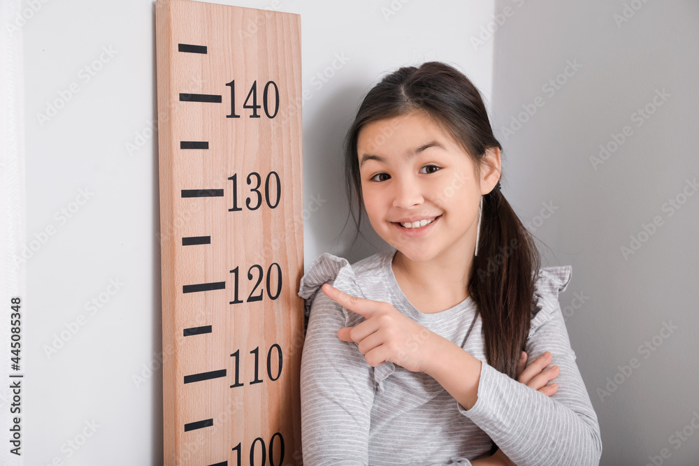 在家测量身高的小女孩