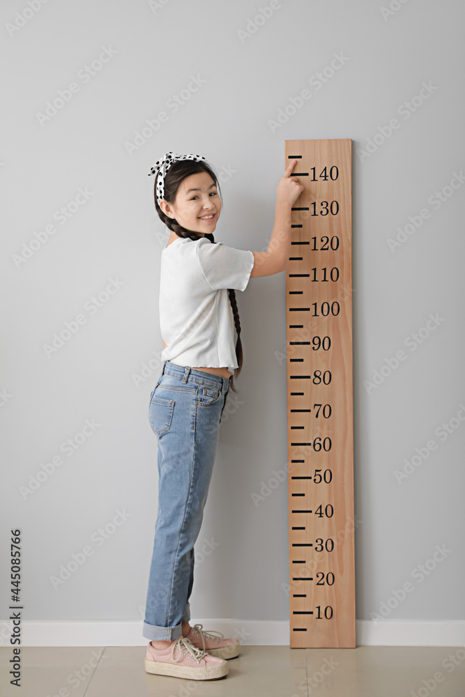小女孩在灯光墙附近测量高度