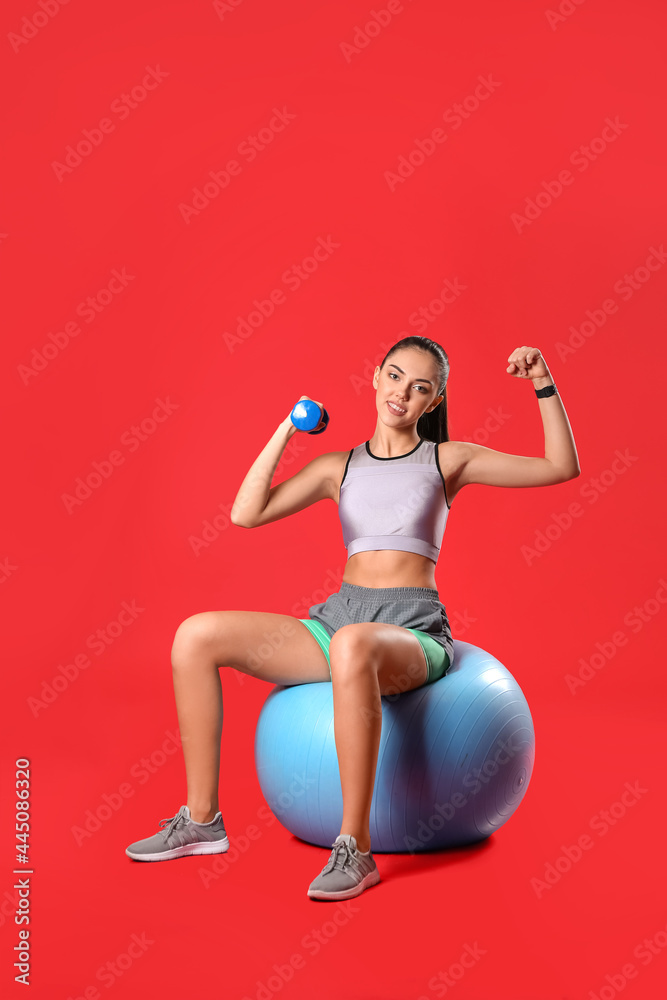 彩色背景健身球和哑铃的运动型女教练