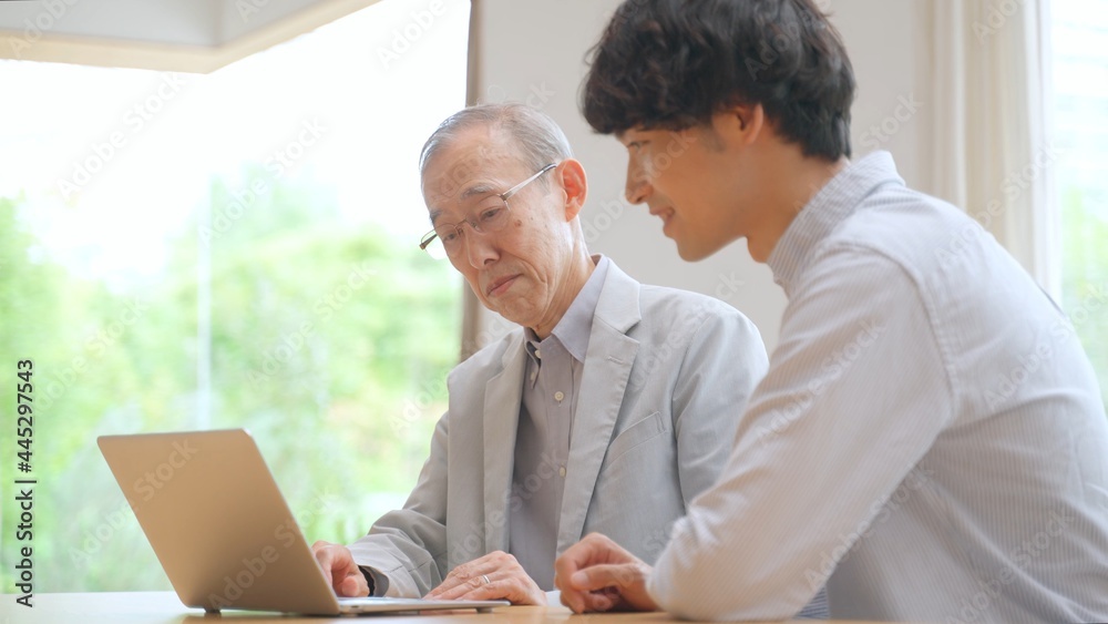 高齢者にパソコンを教える男性