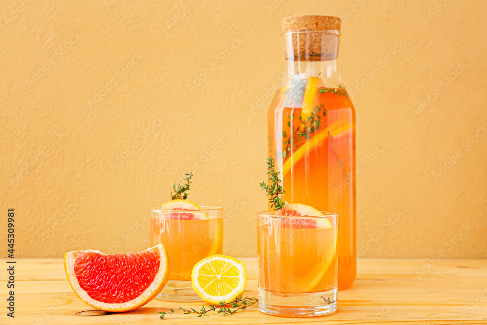 彩色背景的玻璃杯和一瓶美味的葡萄柚汁