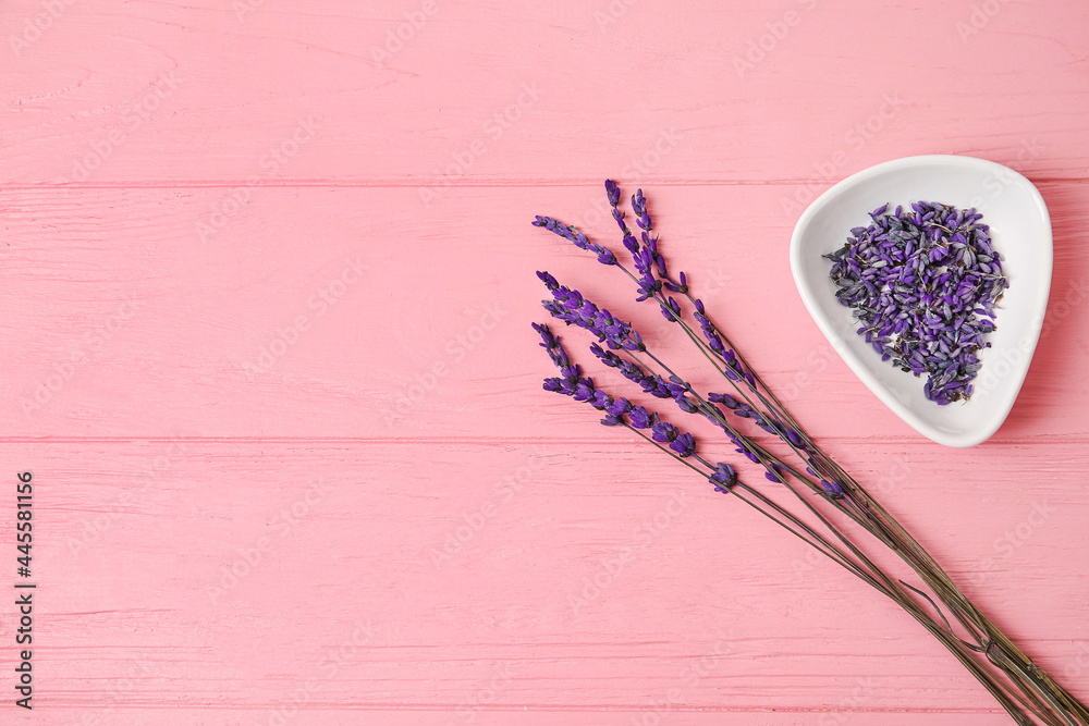美丽的淡紫色花朵和彩色木质背景的碗
