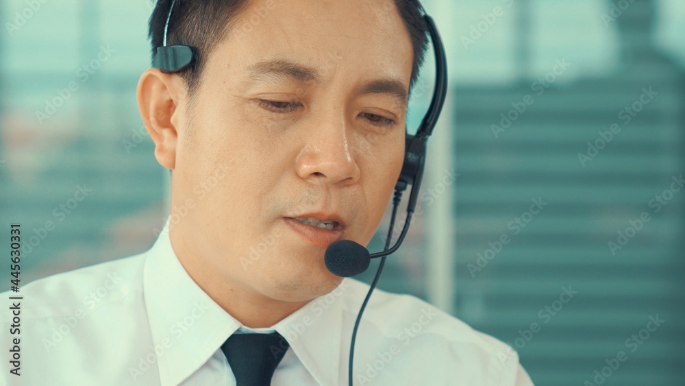 戴着耳机的商人在办公室积极工作。呼叫中心、电话营销、客户支持