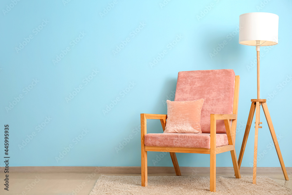 彩色墙壁附近的时尚扶手椅和台灯