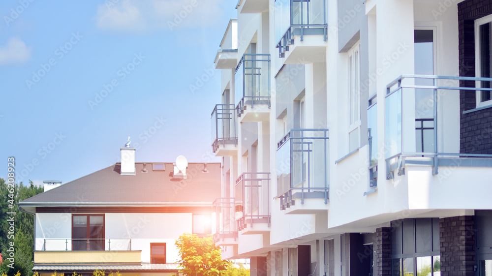 阳光明媚、天空湛蓝的现代公寓楼。现代公寓楼的立面。G