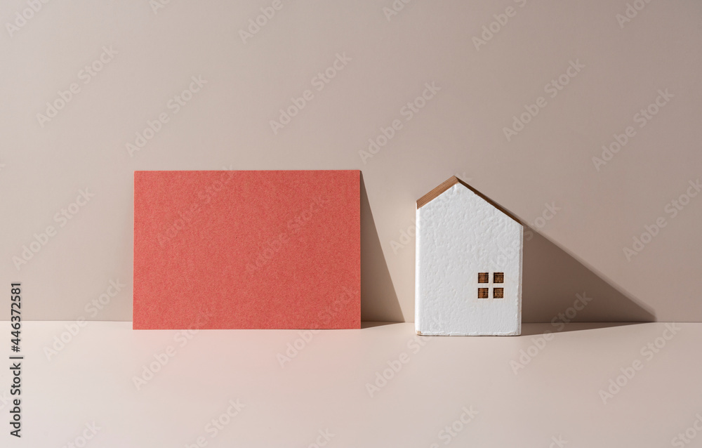 一个米色背景的房子模型，上面有一张什么都没写的卡片。