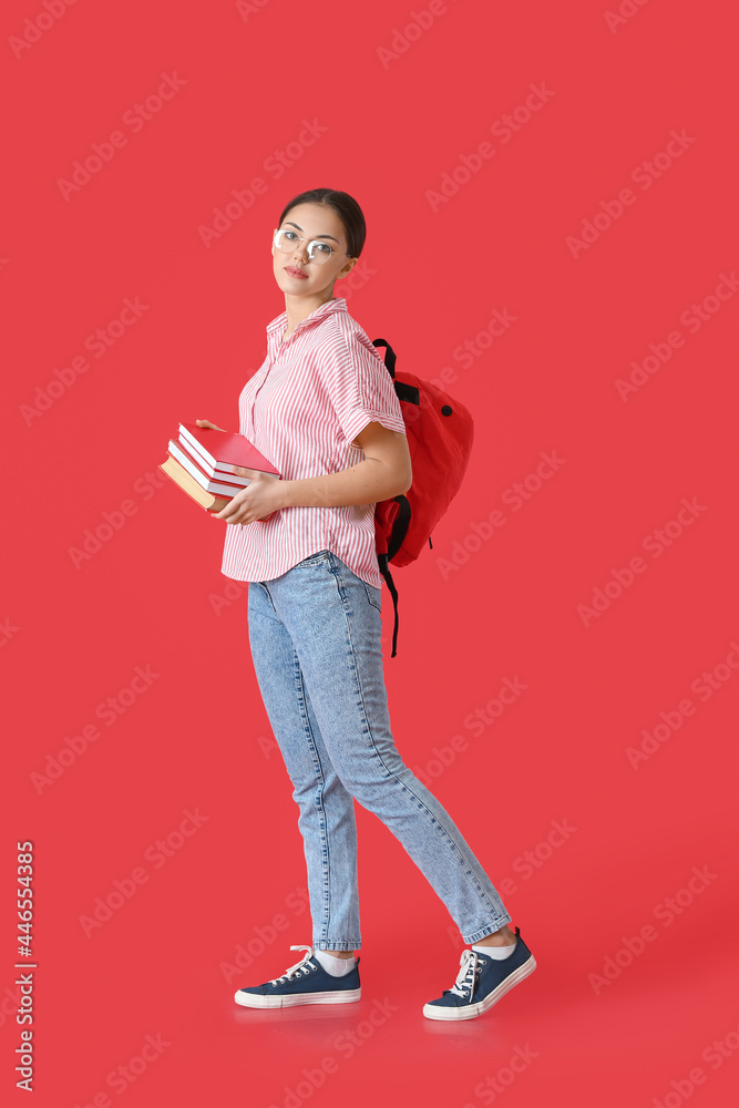Female student with books on color background