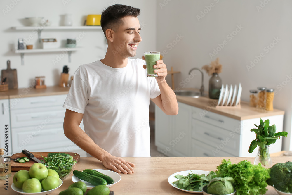 年轻人在厨房喝健康的绿色奶昔